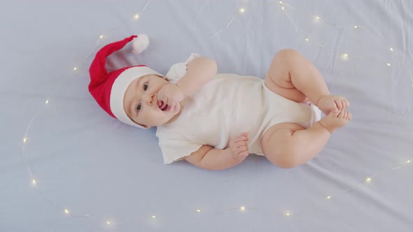 Portrait of Adorable Infant Baby Girl Wearing Santa Hat. Christmas Celebration Concept. alt