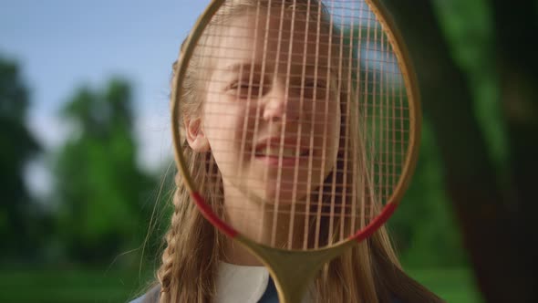 Cute Smiling Girl Look Camera Through Racket Net Closeup alt