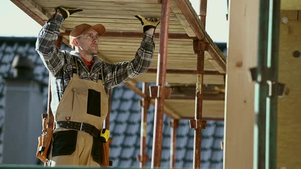 Contractor Worker in His 30s and Scaffolding Assembly. 