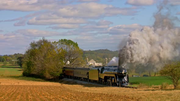 View of An Antique Steam Passenger Train Traveling Thru Trees and Farmlands alt