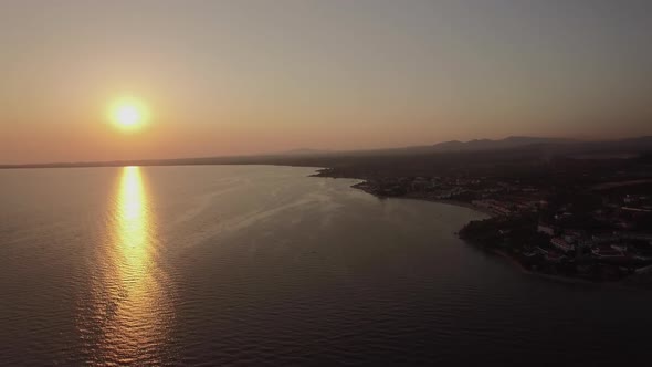 Sea and Coastal Town at Sunset, Aerial. Distant View of Trikorfo Beach, Greece alt