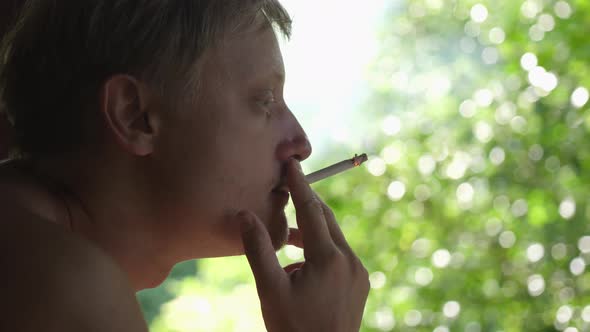 Young Man Smoking Cigarette Outoors