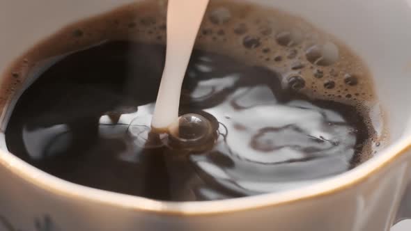 Hot Coffee in Cup with Milk Being Poured in alt