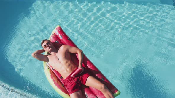 Drone Over Man On Inflatable In Pool alt