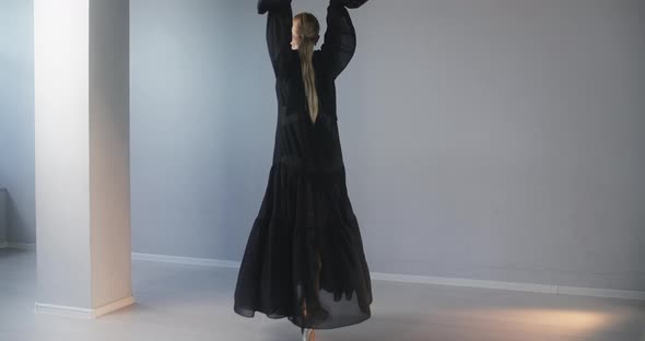 Blonde Attractive Female Dancer with Make Up in Long Black Dress Does Ballet Exercises and Tricks alt