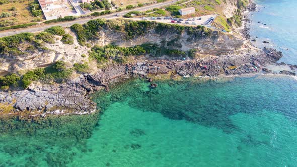 Descendant aerial drone view of coastline with people sunbathing and relaxing alt