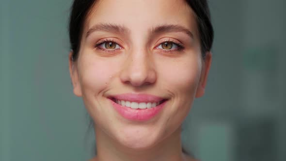 The Girl Smiles at the Camera Tilting Her Head