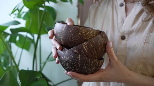 Young Woman Holds Small Brown Bowls in Hands with Manicure alt