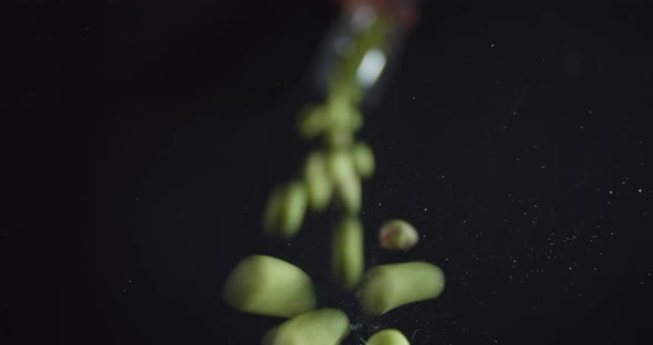 Peanuts Covered in Wasabi Are Falling on the Glass Table,  alt