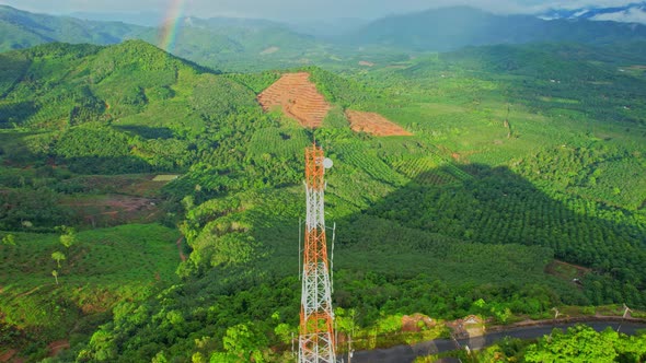 Aerial view over telecommunication towers on green mountain alt
