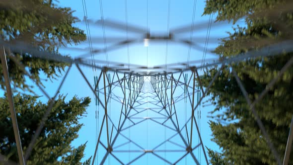 High voltage electricity pylons in a mountain forest. Blue sky in background. 4k alt