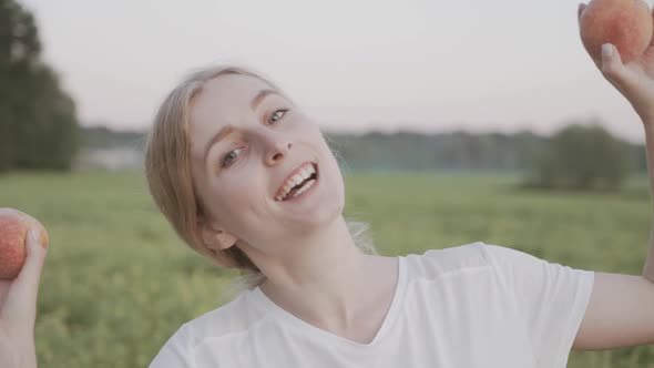Happy Woman in Straw Hat Covering Her Eyes with Peaches on Garden Background alt