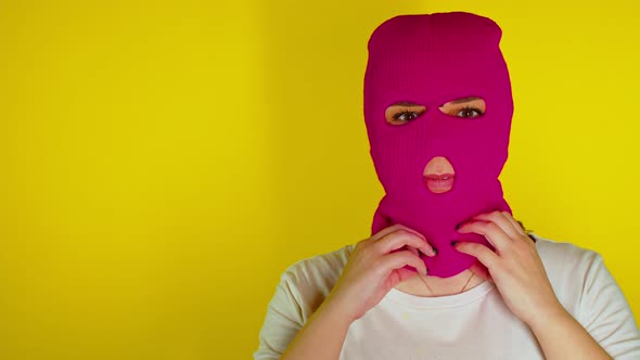 Close Up of Unrecognizable Person in Pink Balaclava on Yellow Background alt