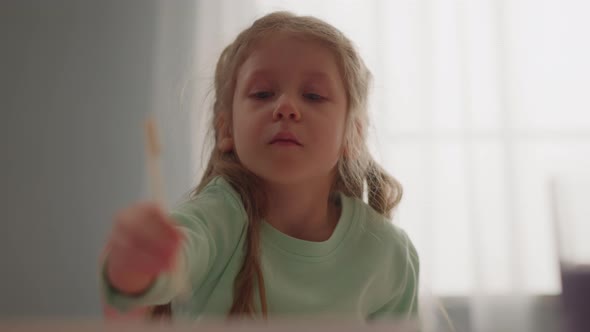 Pretty Little Girl Draws with Stick Making Marbling Pattern alt