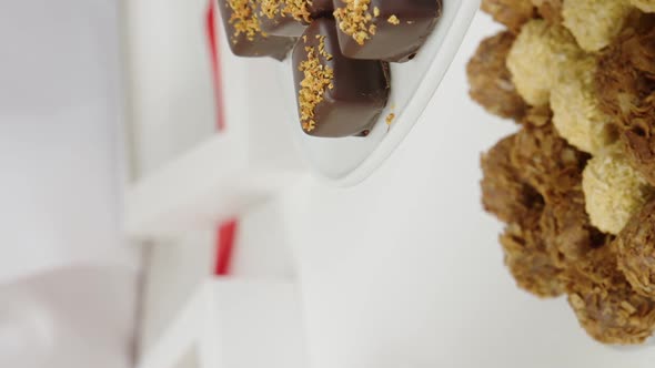 Vertical Shot Closeup Chocolatier Packing Gift Box of Handmade Delicious Chocolate Candies