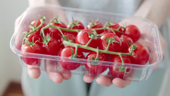 Farmer Shows Ripe Red Cherry Tomatoes Grown on a Plantation for Sale Closeup in Box