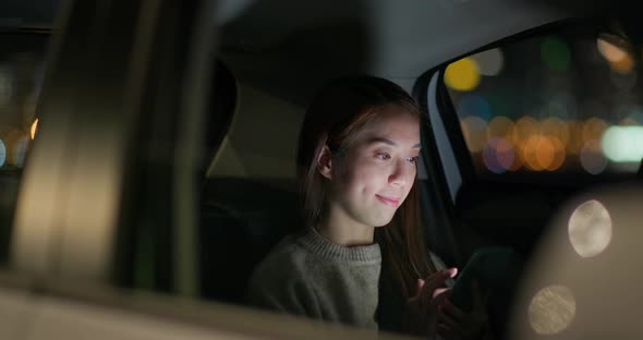 Woman use of mobile phone on car at night