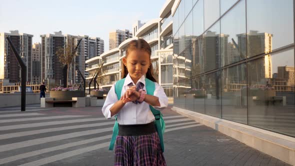 Little Pupil in School Uniform Is Going To School in City Landscape alt