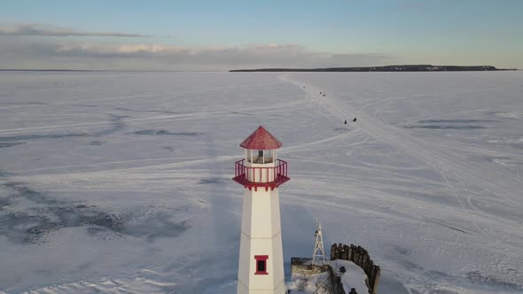 4k drone video of Wawatam Lighthouse in St. Ignace, Michigan during the winter. alt