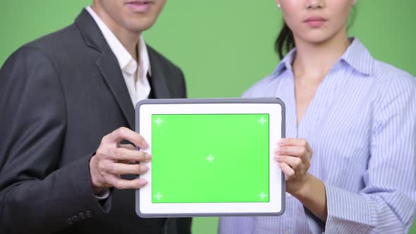 Young Asian Business Couple Showing Digital Tablet Together