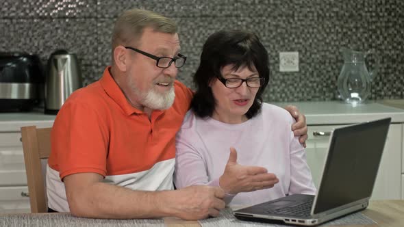 Cheerful Married Couple Are Communicating with Someone Via the Internet alt