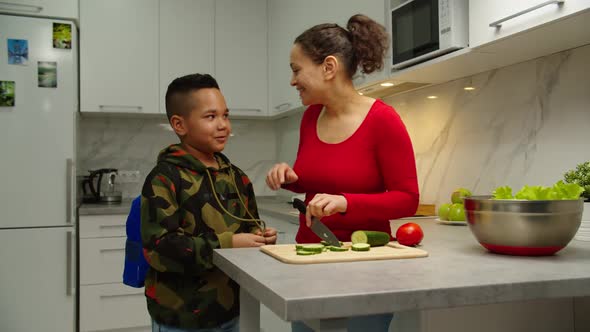 Loving Mother Welcoming Son Kissing Him Asking How Day's Going Indoors alt