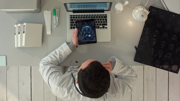 Top View of Man Using Tablet Pc Against Medical Interface on Xray