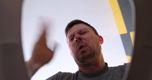 Man with Closed Nose Opening Toilet Lid and Taking Out Clothes with Plunger Bottom View  Movie alt