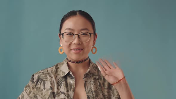 Portrait of Asian Teenage Girl with Braces Chewing Gum alt