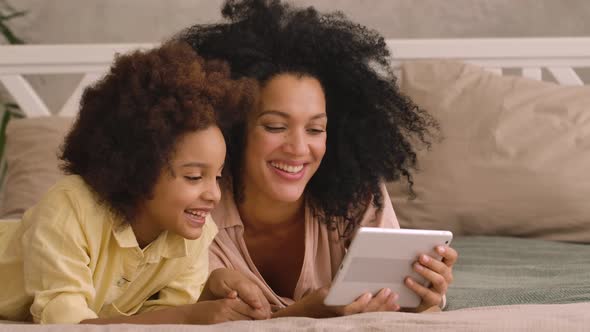 African American Woman and Litle Girl Talking on Video Call Using Digital Tablet alt