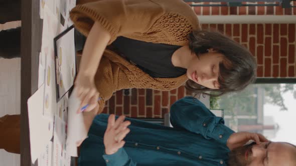 Workmates Looking at Research Papers to Plan Business Project alt