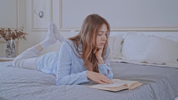 Caucasian Female Reads Novel in Bedroom