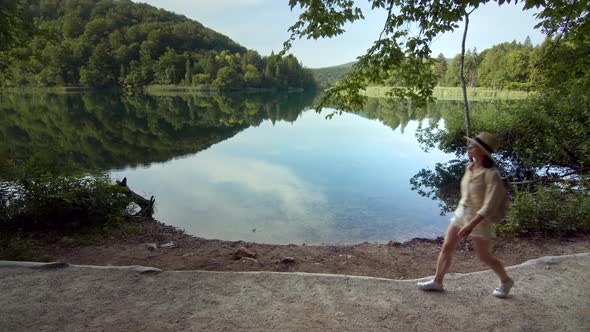 Beautiful girl in a hat walking in a national park alt