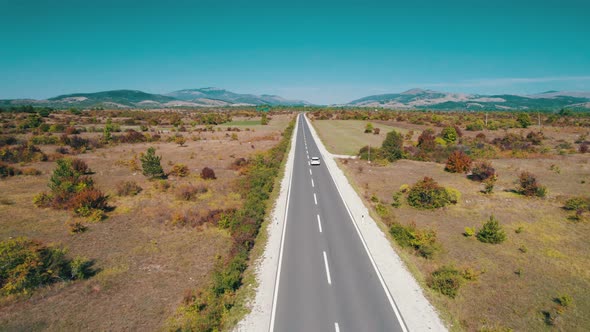 Empty Asphalt Road on the Plateau Between Green Fields Highland Way Aerial View alt