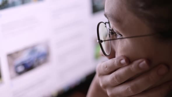 woman reads news on a computer and is amazed at what is happening in the world alt