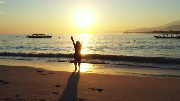 Young fun woman on vacation enjoying life on beach on summer white sand and blue background 4K alt