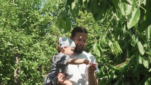 Young Dad with Beard Feeds Child