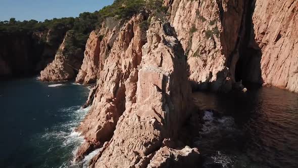 Flying above big rocks, waves, seagulls and a kayak