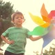 Happy Child Play with Colorful Pinwheel at Sunset Park Outdoor - VideoHive Item for Sale