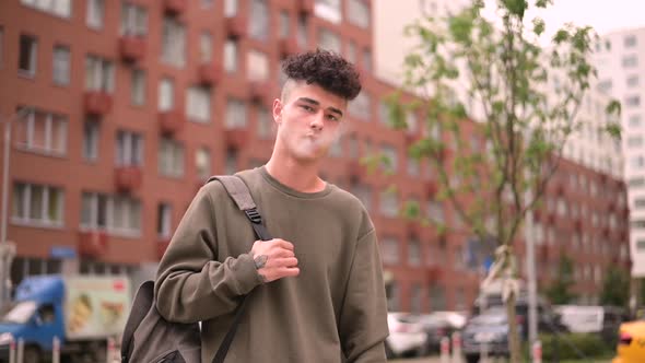 Smoking guy on the background of the cityscape. Slow motion alt