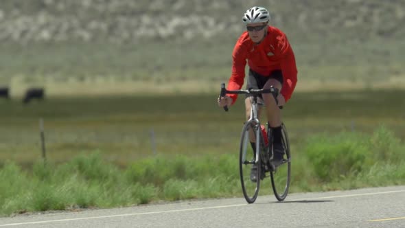 A man road biking on a scenic road. alt