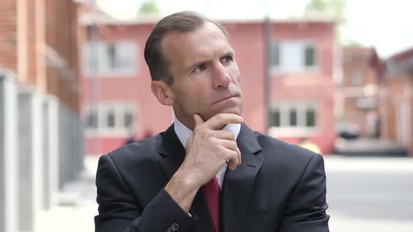 Thinking Middle Aged Businessman in Office alt