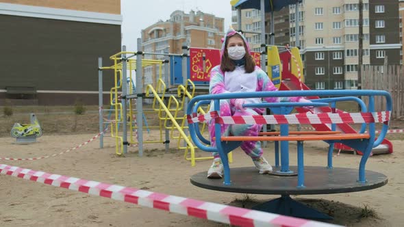 Young Girl in a Protective Mask at the Playground.