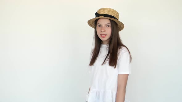 Calm Little Girl Standing in Swimming Wear and Panama Hat Isolated Over White Background alt