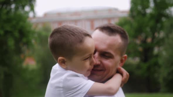 Beautiful Family Two Dad and Son are Stand on a Green Meadow in Summer alt