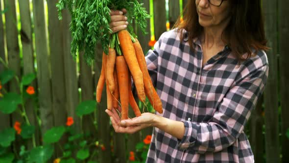 Mature woman holding carrot vegetable alt