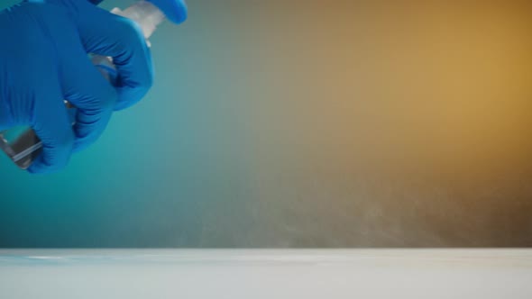 Hand in Protective Glove Wiping Table with Antiseptic and Cloth Closeup alt