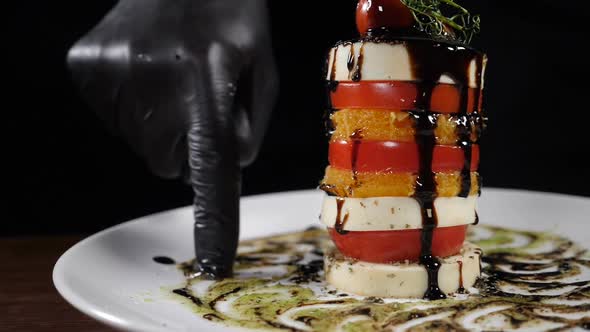 Slow Motion Food Video Concept. Salad Caprese on White Plate Poured with Balsamic Reduction. Sliced alt
