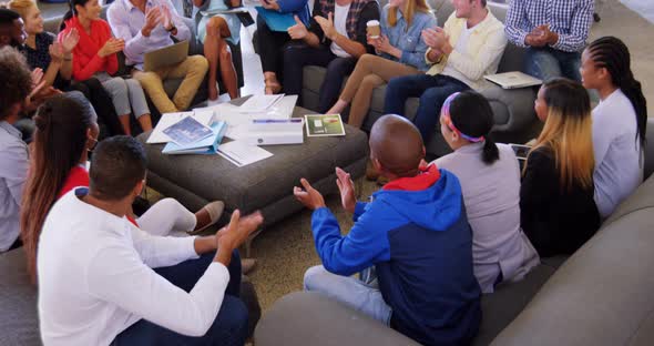 Group of business executives applauding during meeting alt