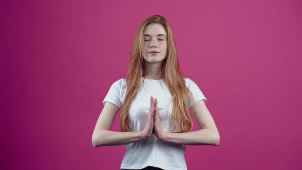 Portrait of a Beautiful Young Woman Meditating with Her Hands Clasped to Her Chest alt